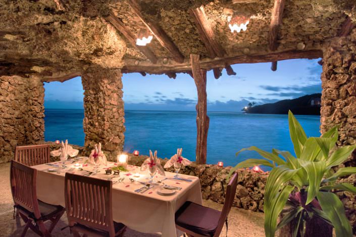 Romantic private table setting in a grotto overlooking ocean
