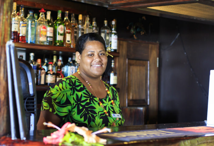Fijian woman standing behind hotel bar
