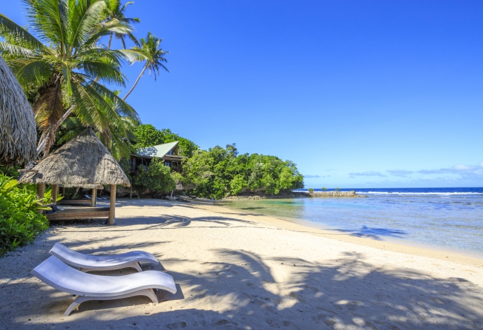 tropical private beach with two lounge chairs
