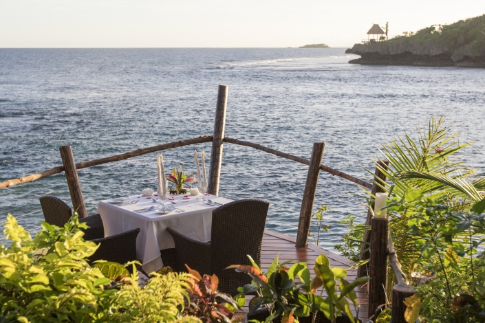 Private table setting overlooking ocean and sunset in fiji