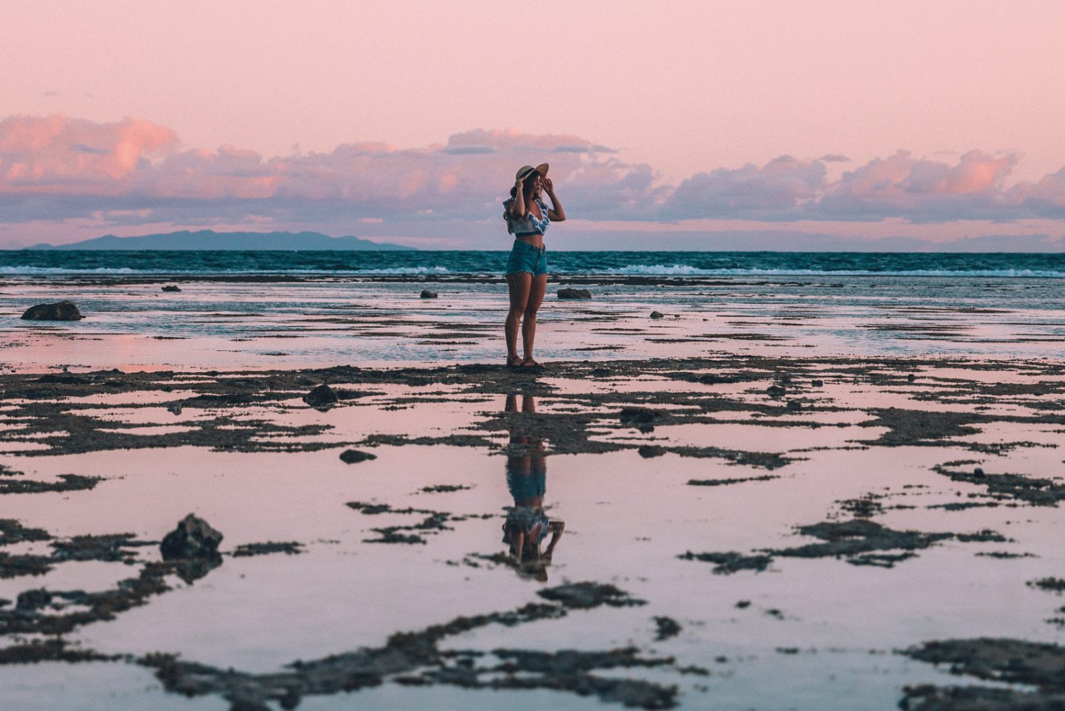 Woman walking along reef at low tide
