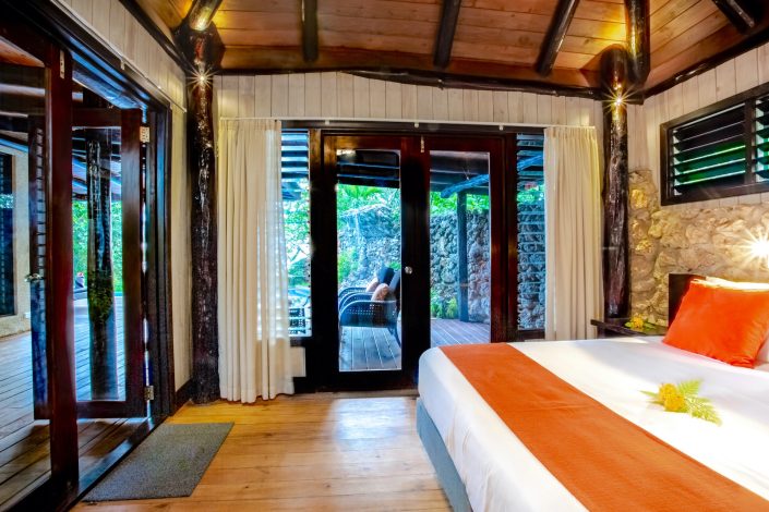 Luxurious Fijian style villa bedroom with orange decor