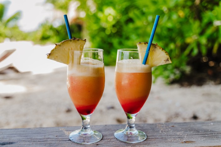Two tropical cocktails on a table by the beach