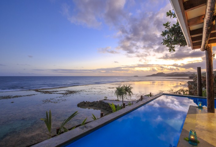 Sunset view overlooking the ocean and a private villa swimming pool