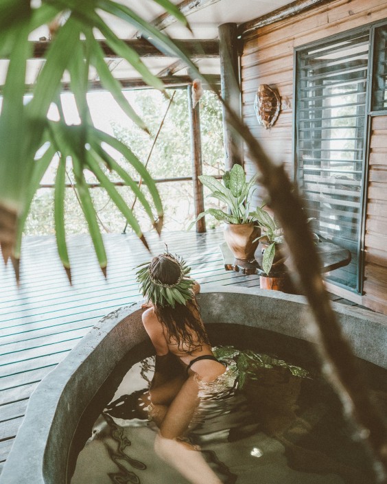 Woman relaxing in private stone bath tub in Fiji