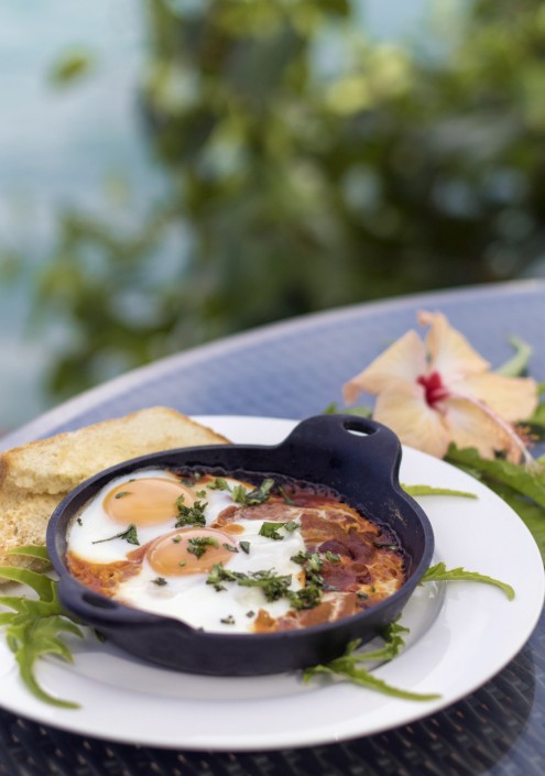 Portrait image of baked eggs in a cast iron pan with two slices of toast