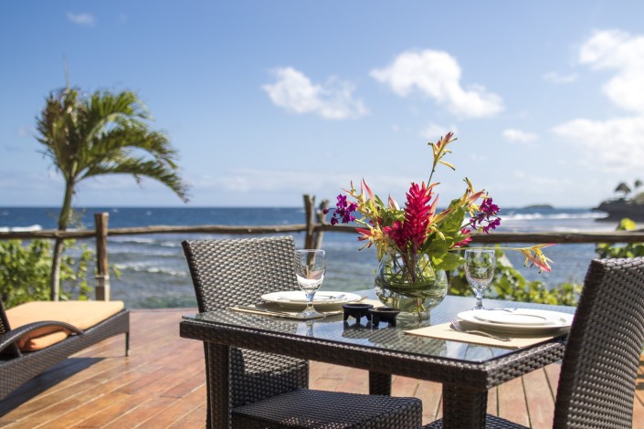 Private outdoor table setting for two on a deck overlooking ocean