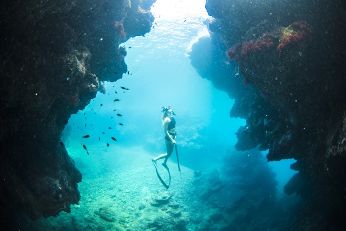 Woman swimming underwater with spearfishing gun in Savusavu Fiji