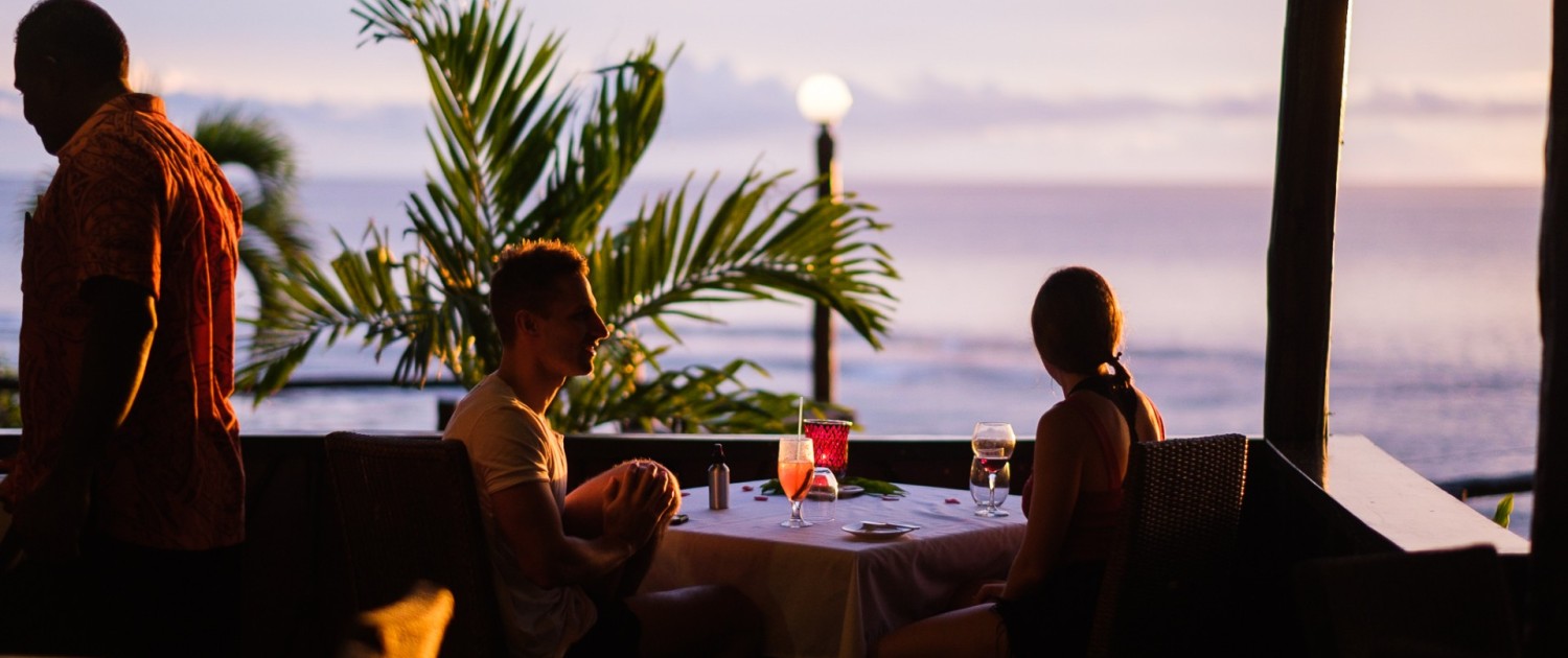 couple dining at sunset overlooking ocean