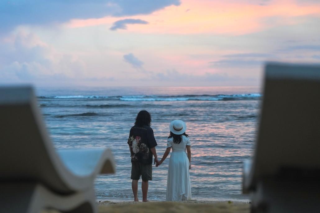 A couple holding hands by the beach