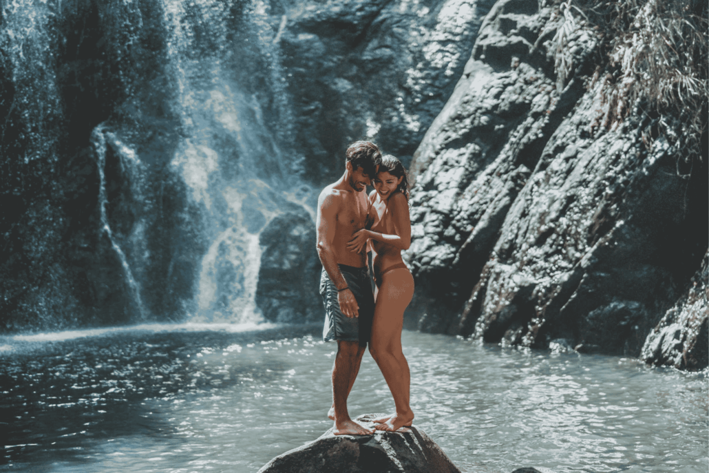 A couple are embracing by the waterfall in Savusavu, Fiji